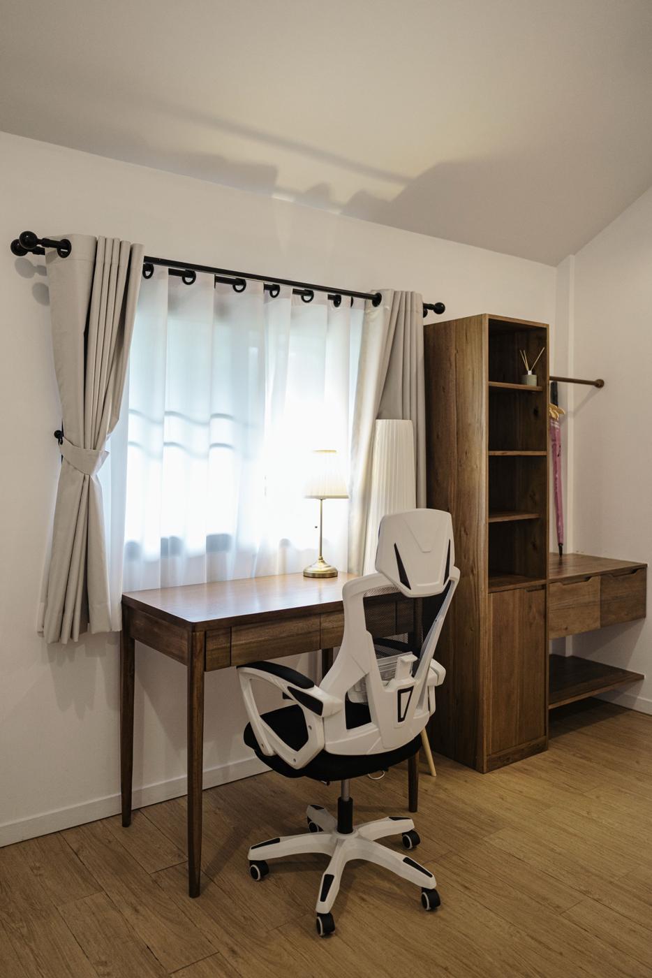 Wooden desk and work chair by the window
