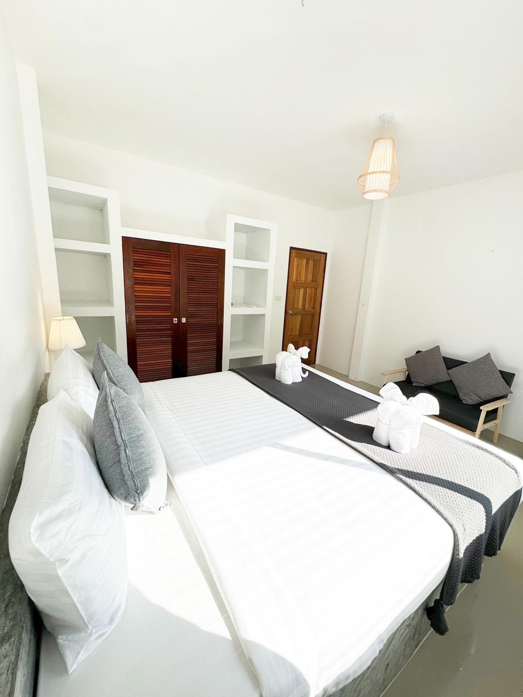 Bedroom with wardrobe, shelves and a small sofa