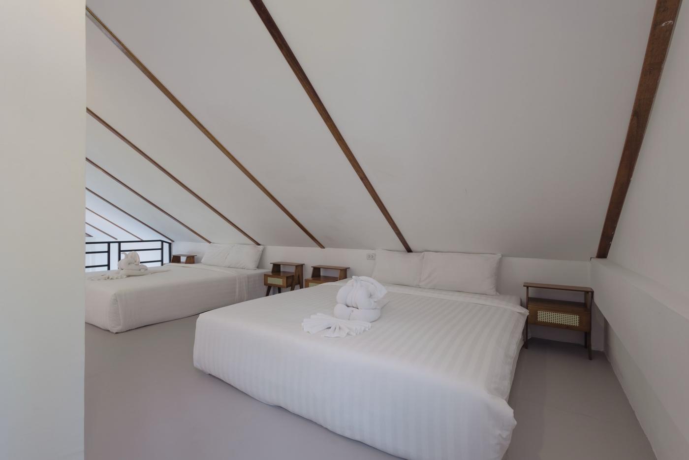Gallery bedroom with two king beds under the roof beams