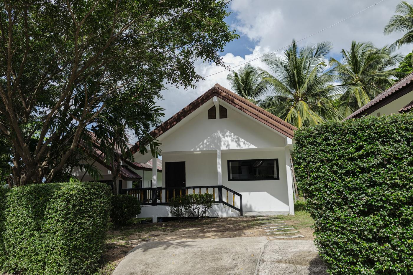 White house with a porch among palm trees