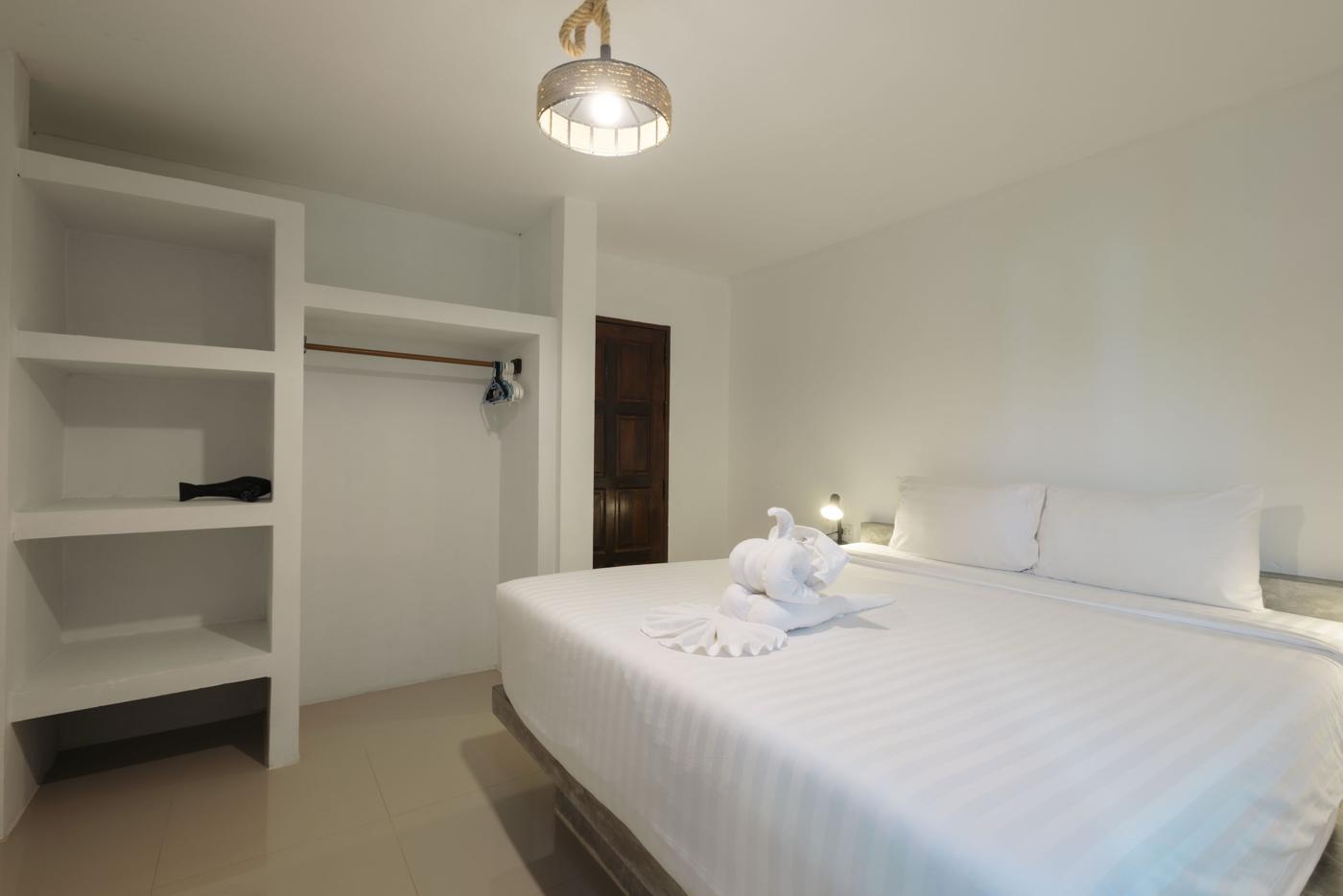 Bedroom with king bed and open wardrobe shelves