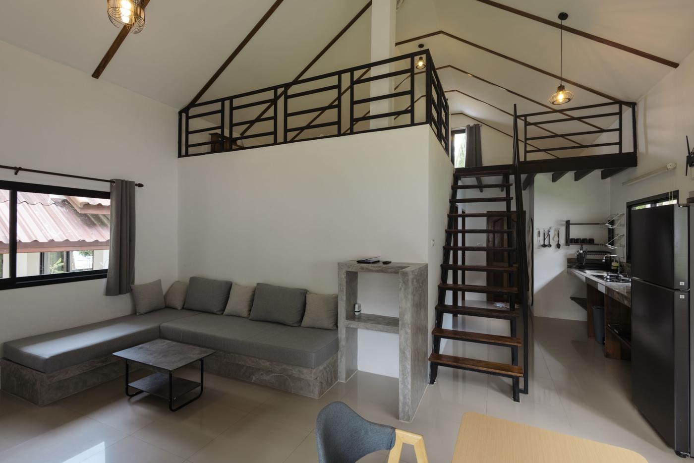 Living room with corner sofa, gallery above and stairs