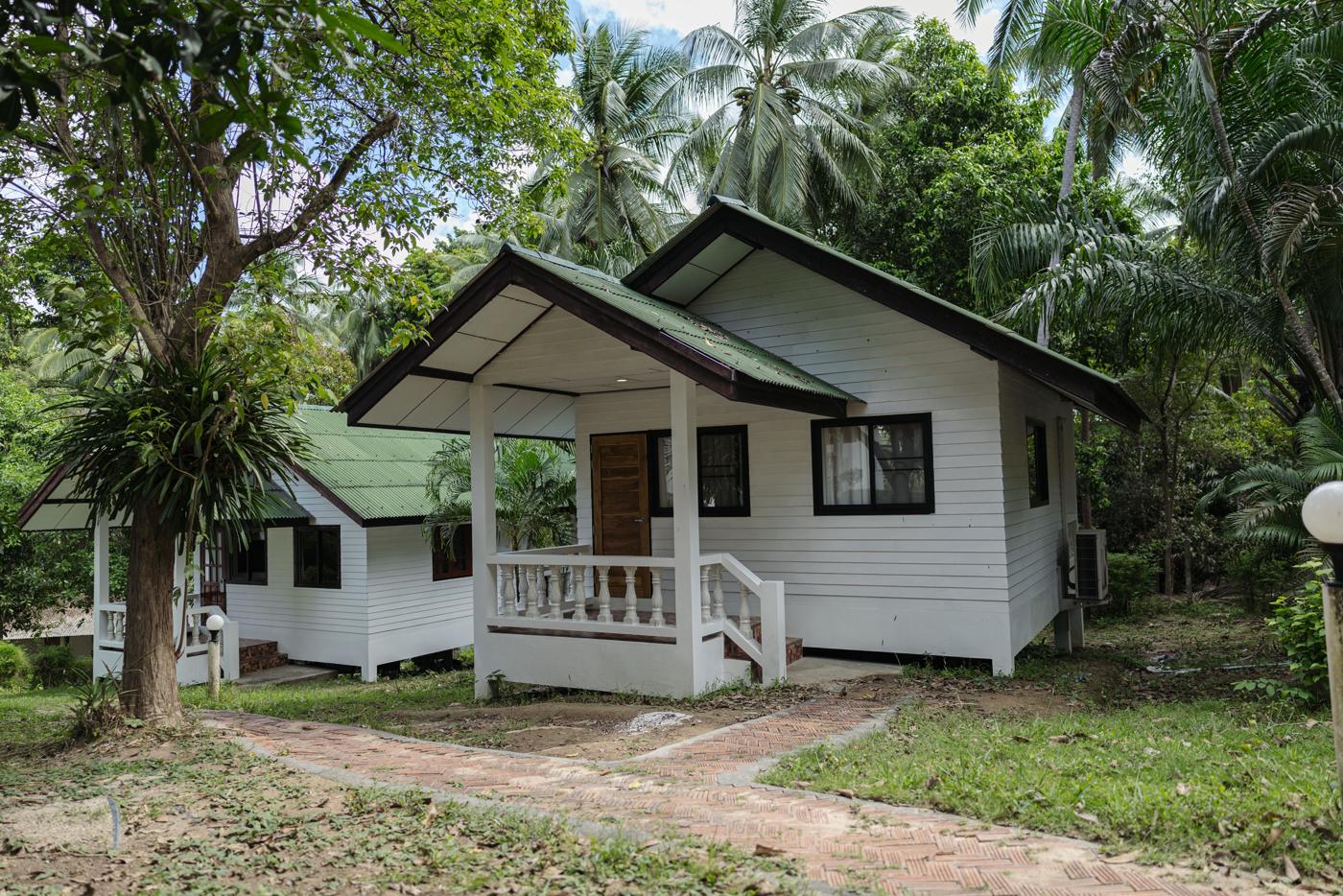 White Deluxe Bungalow with porch among palm trees